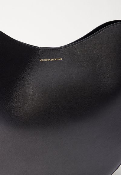 Geantă din piele neagră cu un finisaj neted, având un design cu un vârf curbat și detaliul logo-ului auriu "VICTORIA BECKHAM".