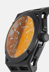 Schwarze analoge Armbanduhr mit einem orangefarbenen Ziffernblatt, ausgestattet mit silbernen Akzenten, zwei Nebensubdials und einer Wasserdichtigkeitsmarkierung von 10 BAR.