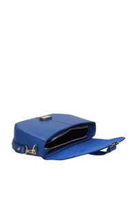Sac à main en cuir bleu avec une fermeture magnétique, présentant un extérieur lisse, un intérieur noir doublé, et une sangle réglable. Compartiment zippé visible.