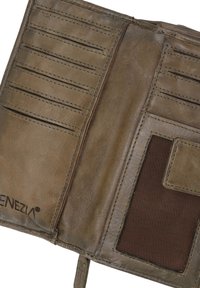 Indvendig på en brun læderpung med flere kortlommer, en mørk stoflap og synlige syninger. Loge prægning nederst til venstre.