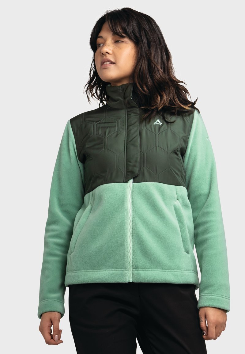 Fleecejacke mit einem mintgrünen unteren Abschnitt und einem dunkelgrünen, hexagonal gemusterten oberen Abschnitt. Mit hohem Kragen und Reißverschluss.