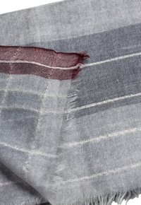 Grå og burgunder mønstret tekstil med frynset kanter, der har horisontale striber i varierede bredder i en blød, vævet struktur.