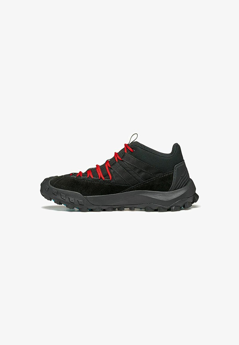 Scarpe da trail nere realizzate con una combinazione di materiale sintetico liscio e suede testurizzato, con lacci rossi e suole con trazione robusta.