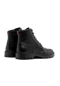 Czarne skórzane botki za kostkę z sznurowanym przodem, solidną podeszwą i teksturowanym wykończeniem. Oferują mały kolorowy akcent na pięcie.