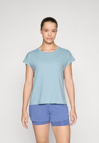 Camiseta de manga corta azul claro con cuello redondo y corte relajado, combinada con pantalones cortos deportivos azules. Tejido suave y textura lisa.