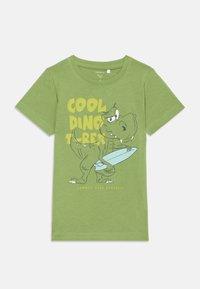 Zielona bawełniana koszulka z krótkim rękawem z rysunkiem cartoonowego T-Rexa z deską surfingową, z napisem "FAJNY DINOZAUR T-REX" w kolorze żółtym, o swobodnym kroju.
