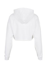 Īsa balta kapuce no mīksta auduma ar aukliņu kapuces regulēšanai, garām piedurknēm un ribotām aprocēm. Tīrs un minimāls dizains.