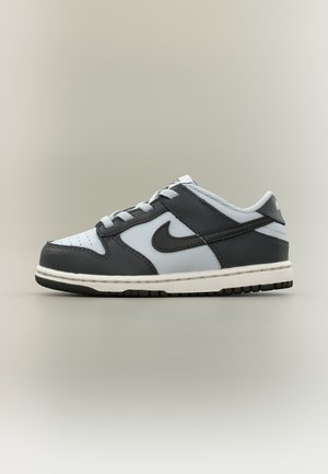 Sneaker Nike basse in pelle bianca e nera con lacci e suola piatta in gomma.