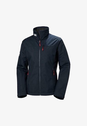 Chaqueta impermeable azul marina con un cuello alto, acentos de cremallera roja y dos bolsillos laterales. Presenta una textura suave y un diseño moderno y ajustado.