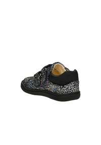 Sneaker noire avec une tige texturée présentant des motifs multicolores éparpillés, un système de laçage et un talon noir rembourré. Semelle plate en caoutchouc.