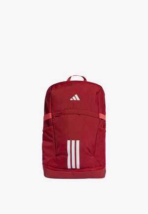 Zaino rosso Adidas con tre strisce verticali bianche sulla tasca frontale e logo Adidas sopra, dotato di tasche laterali in rete e maniglia superiore.