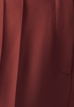Tamno crvena tkanina sa suptilnom teksturom, prikazom vidljivog šavova i bočnim džepom. Dizajn ravnog kroja, minimalistički izgled.