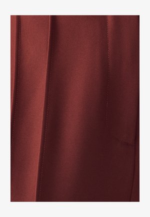 Tamno crvena tkanina sa suptilnom teksturom, prikazom vidljivog šavova i bočnim džepom. Dizajn ravnog kroja, minimalistički izgled.