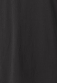 Tela de algodón negra con una textura suave, mostrando ligeras arrugas y un color uniforme en toda su extensión. Sin patrones visibles ni detalles de hardware.