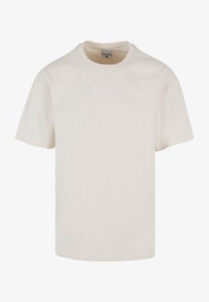 Krémszínű, rövid ujjú póló, puha pamutból készült. Minimalista fehér hímzett logóval rendelkezik a mellkason. Klasszikus kerek nyakkivágású.