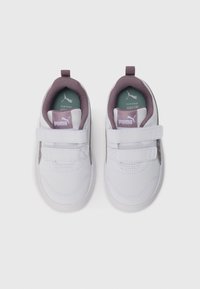 Vita småbarnsskor i vitt med lila foder, två kardborreband och Puma-logotyp på tungan och innersulorna, visade från ovansidan.