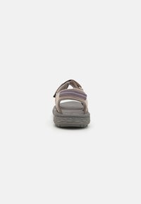 Brune justerbare sandaler med teksturert gummisåle, stoffstropper i beiger og lilla nyanser, med polstret fotseng og bakre hældesign.