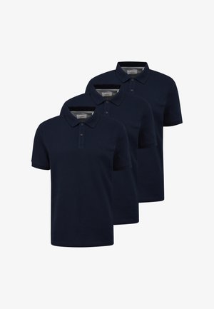 Tre marineblå poloer med korte ærmer og knappede kraver arrangeret i en forskudt stak på en hvid baggrund.