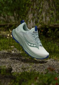 Scarpa da corsa leggera in verde menta e bianco, con tomaia texture, accenti blu e suola ammortizzata con modelli di trazione.