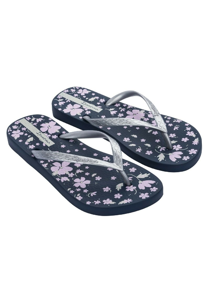 Chanclas con una base azul oscura, patrones florales en rosa y tiras plateadas. Plantilla texturizada para mayor agarre. Su construcción de goma delgada asegura flexibilidad.