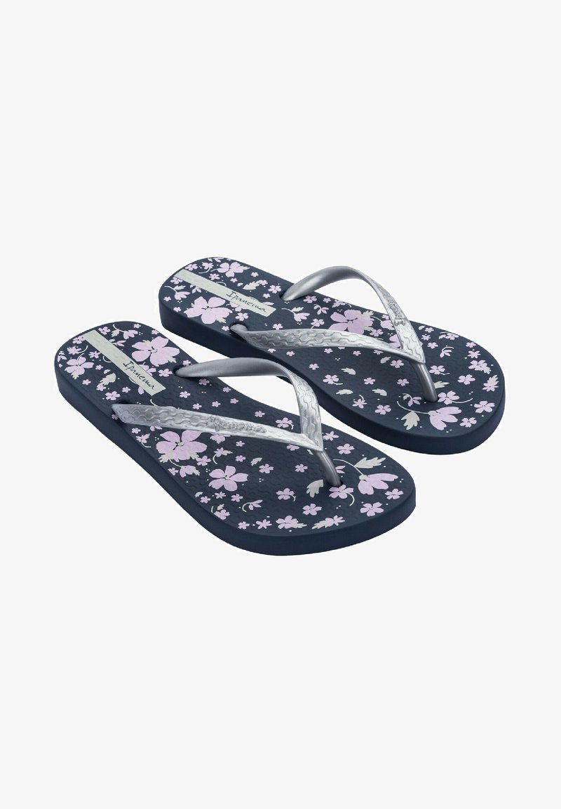Chanclas con una base azul oscura, patrones florales en rosa y tiras plateadas. Plantilla texturizada para mayor agarre. Su construcción de goma delgada asegura flexibilidad.