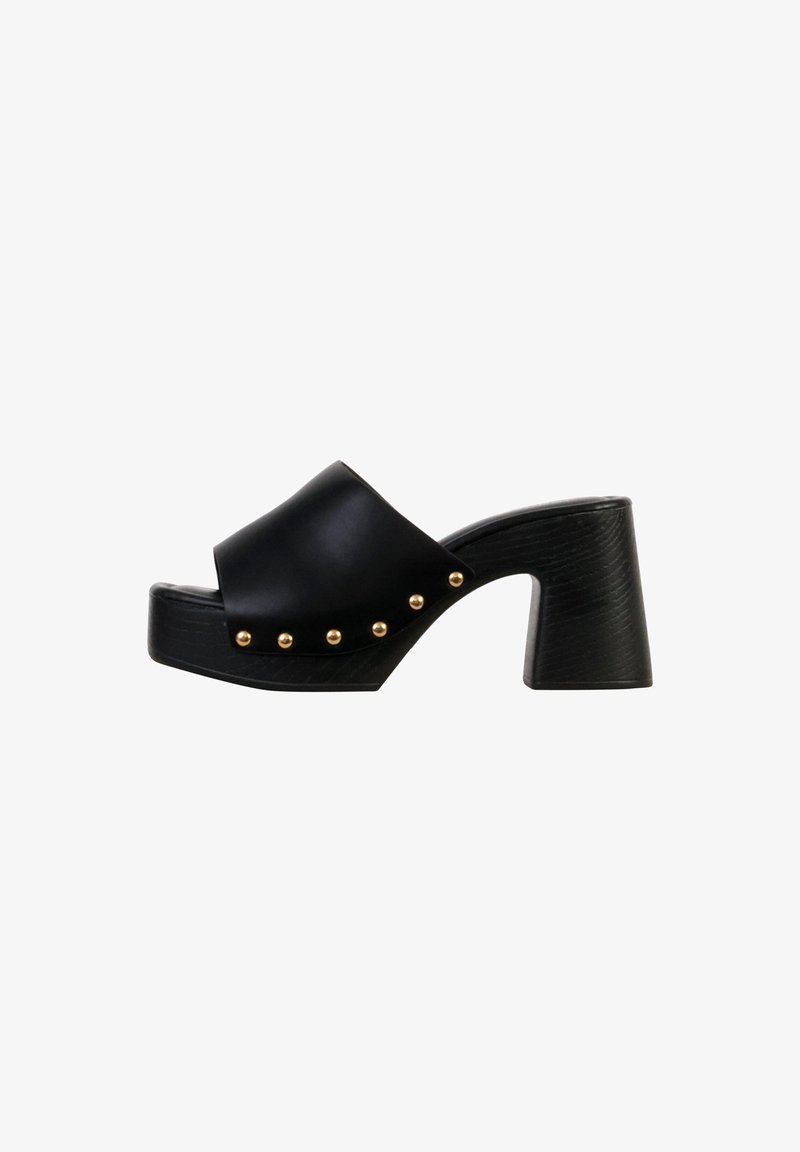 Mule en cuir noir à bout ouvert avec un talon épais, semelle à texture de bois et clous dorés le long du côté de la bride supérieure.