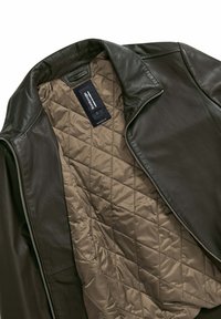 Donkergroene leren jas met een gewatteerde beige voering. Beschikt over een ritssluiting en een staande kraag voor extra warmte en stijl.