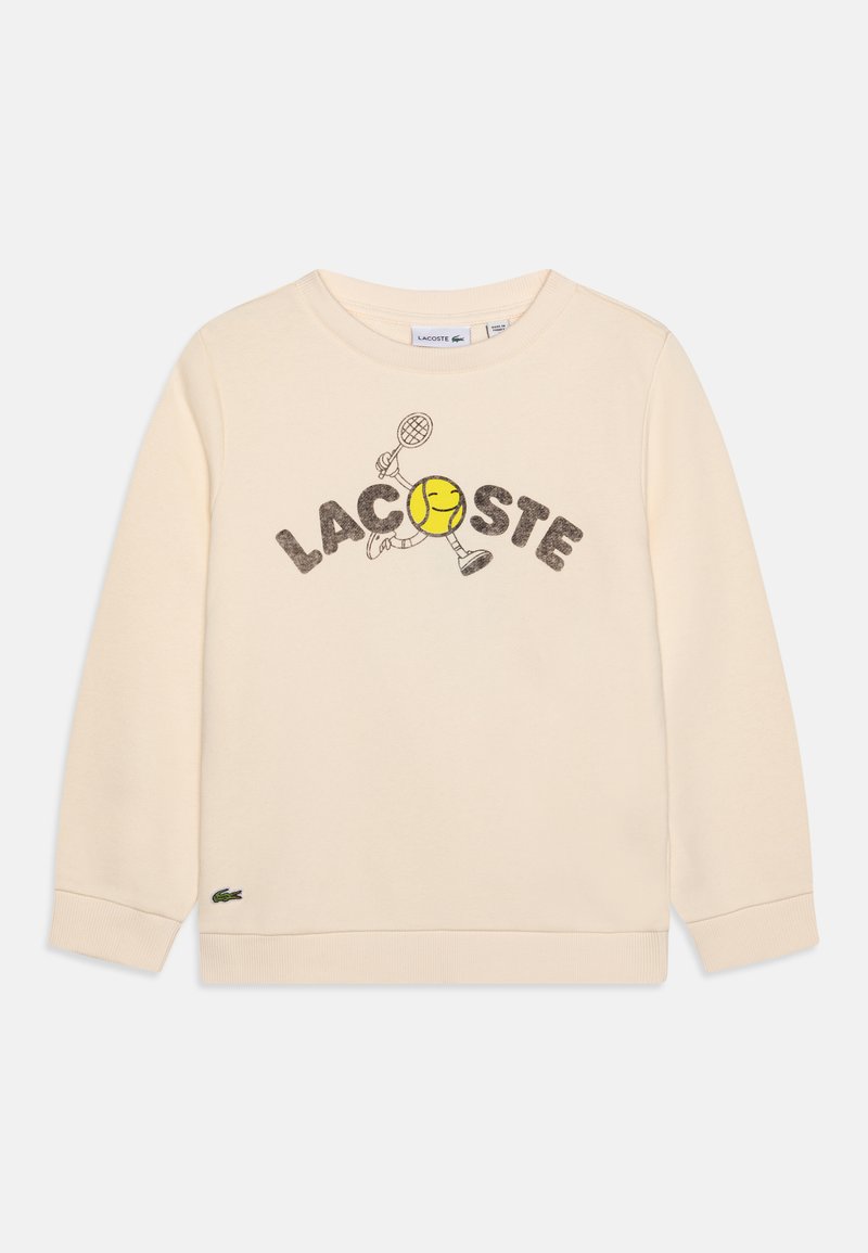 Crèmekleurige sweatshirt met de tekst "LACOSTE" en een speelse tennisbalgrafiek. Ribgebreide manchetten en zoom, met een klein logo op de onderste linkerhelft.