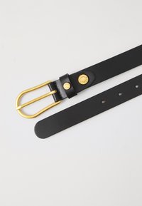 Svart lærbelte med gullmetall dobbelt-prong spenne. Har en jevn tekstur og rund gullaccent nær spennen.