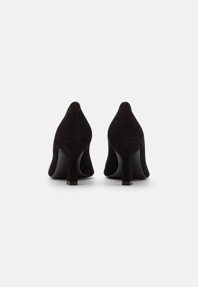 Sorte ruskinds højhælede sko med spids tå og en solid blokhæl, der har en glat overflade og et enkelt design.
