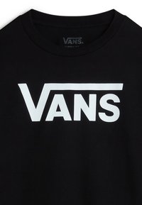 Musta puuvillainen T-paita, jossa on suuri valkoinen "VANS"-logo. Suunnittelussa on pyöreä kaula-aukko ja klassinen malli. Pehmeä rakenne.