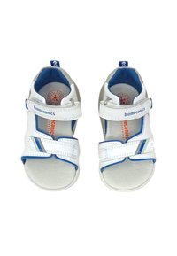 Sandali in pelle bianca con dettagli blu, cinturini regolabili e suole imbottite. Dettagli del logo e del marchio ben visibili sulle solette.