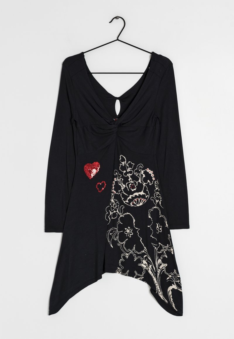 Black long-sleeve dress with asymmetrical hem, white floral print, and two red sequin hearts on front, hanging on black hanger.