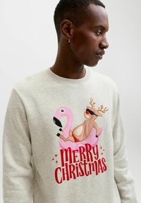Lichtgrijze sweatshirt met een kleurrijk kerstontwerp van een roze flamingo en een rendier. De tekst luidt "VROLIJK KERSTFEEST" in het rood.