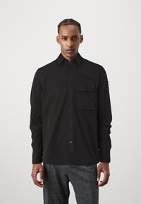 Black long-sleeve shirt with a button-down collar and single chest pocket, made from a smooth fabric, features front button closure.