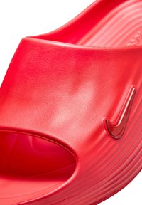 Κόκκινο σανδάλι τύπου slip-on με λογότυπο Nike, ανοιχτή μύτη και υφασμένο πέλμα, σχεδιασμένο για καθημερινή χρήση και άνεση.