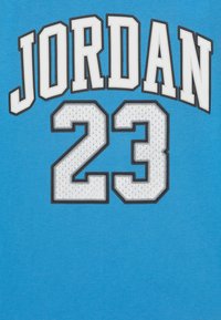 Modré bavlněné tričko s bílým nápisem "JORDAN" a číslem "23", s vyšívanými detaily a texturovaným vzorem na číslech.