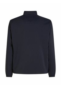 Giacca blu navy realizzata in tessuto leggero, con collo alto e polsini elasticizzati, dalla texture liscia e dettagli di design minimalisti.