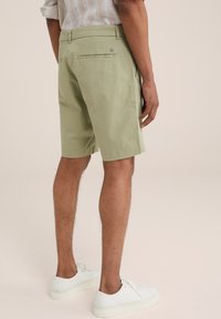 Svetlozelené šortky vyrobené z oblečenia z bavlny, s rovnými nohavicami, dvoma zadnými vreckami a malým logom na jednom vrecku.