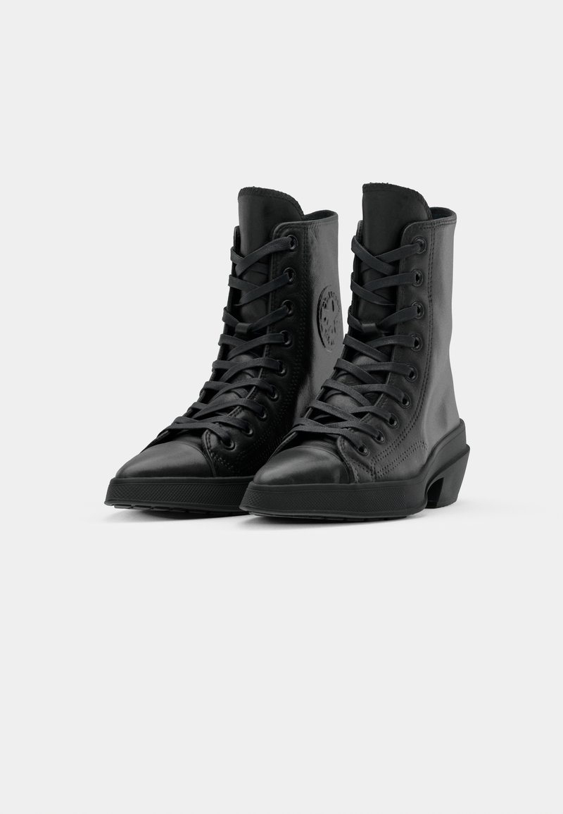 Bottes hautes noires en cuir avec lacets, bout renforcé, logo distinctif sur le côté et semelles en caoutchouc texturé pour une meilleure adhérence.