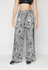 Παντελόνι σε μαύρο και άσπρο σχέδιο με γεωμετρικά και λουλουδάτα μοτίβα. Διαθέτει ελαστική μέση και πλαϊνές ρίγες.