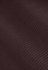 Teksturowana ciemnobrązowa tkanina z falistym wzorem składającym się z naprzemiennie wypukłych i płaskich pasków, tworzących efekt falowania.