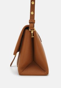 Borsa a mano in pelle marrone con superficie testurizzata, base triangolare e dettagli in metallo dorato. Dotata di una tracolla regolabile con bottoni a pressione.