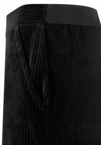 Le pantalon en velours côtelé noir présente une surface texturée avec des côtes verticales, une taille extensible et des poches latérales pour plus de fonctionnalité.