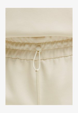 Bež jogger hlače s pojasom na vezanje, mekim materijalom i pojasom s elastikom za prilagodljivu udobnost.