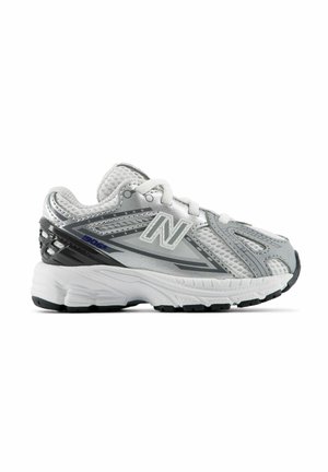 Grau-weißer New Balance Laufschuh mit Mesh-Obermaterial, gepolstertem Kragen, dicker weißer Sohle und schwarzen Details an Ferse und Sohle.