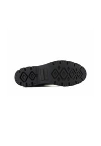 Suela de zapato de goma negra con un patrón de banda de rodadura que presenta formas hexagonales y rectangulares, ofreciendo agarre y estabilidad. Detalle de la superficie texturizada visible.