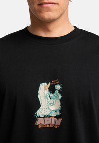 Sorte bomulds t-shirt med et grafisk motiv af en yeti med fed skrift "ADIV" og "Built To Last" i orange på brystet.