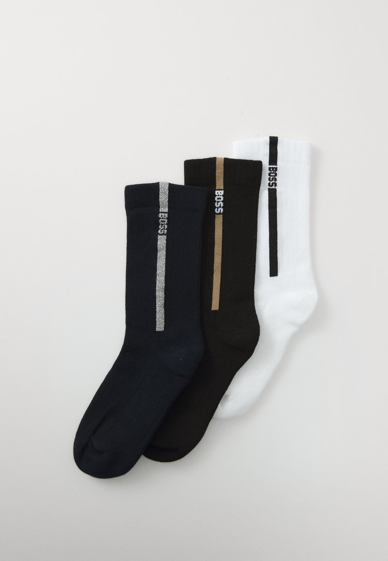 Tres pares de calcetines de tripulación en negro, marrón oscuro y blanco, cada uno con una franja vertical y el logo "BOSS" cerca de la parte superior.