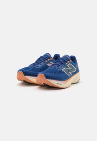 Baskets de sport bleues avec une tige en mesh, accents gris clair et semelle texturée. Présente un logo 'N' visible et une semelle intermédiaire rembourrée.